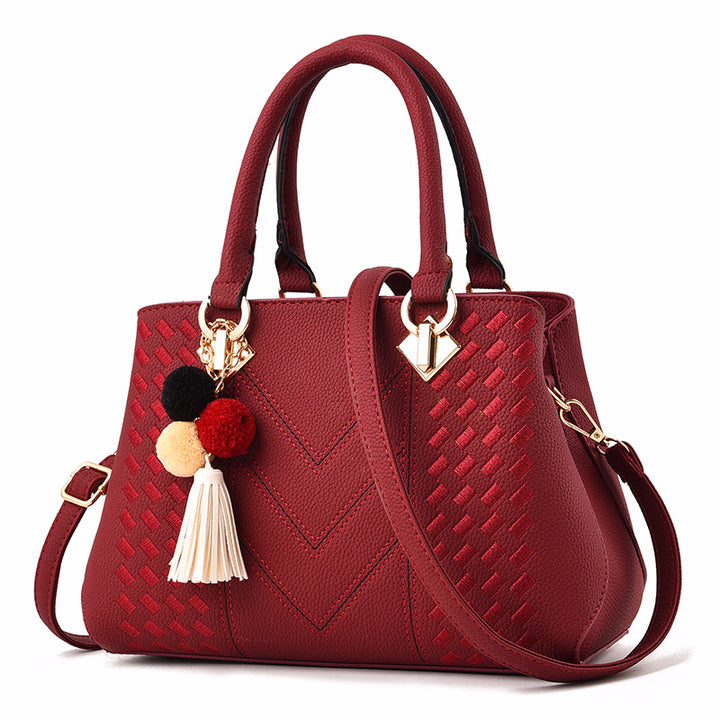 Embossed top handle handbag with pompom