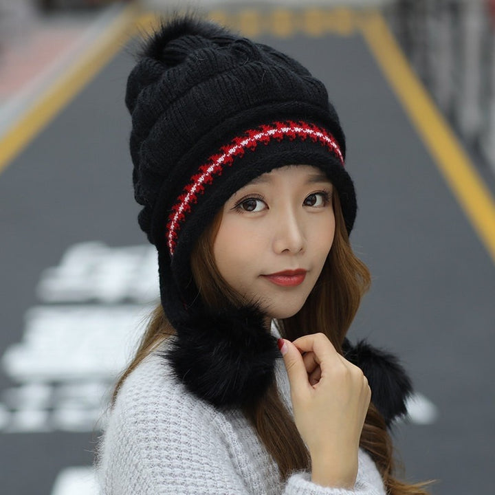 Woman in a knitted bobble hat with ear flaps