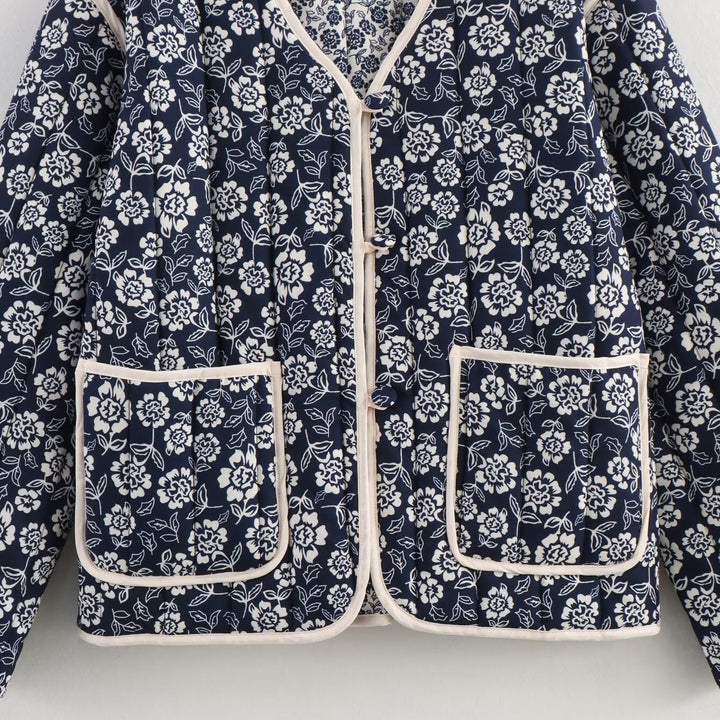 Ladies quilted jacket with floral allover, V-neck, contrast piping and patch pockets