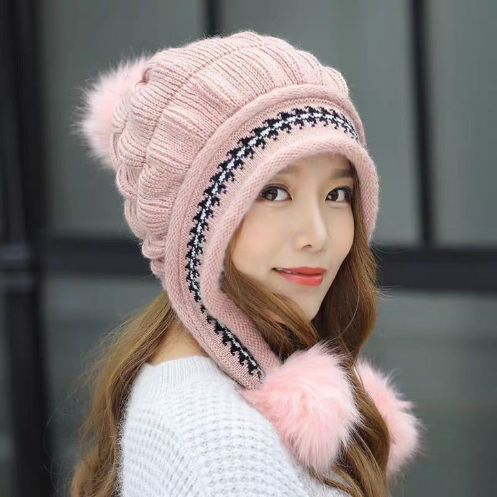Woman in a knitted bobble hat with ear flaps