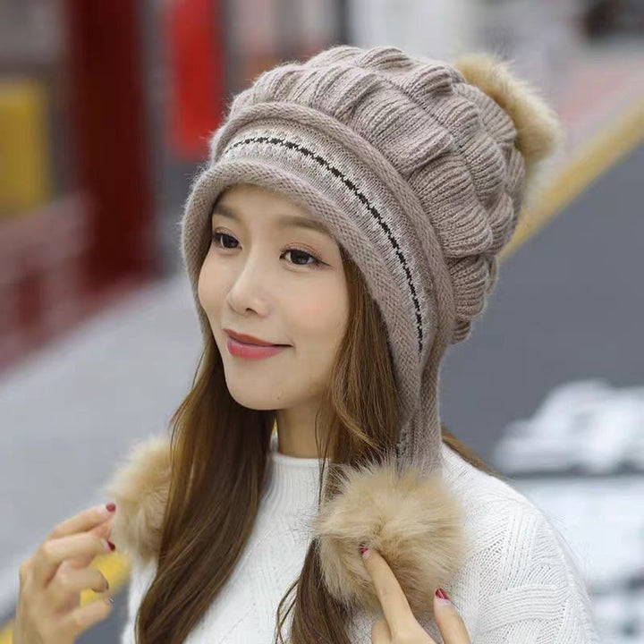 Woman in a knitted bobble hat with ear flaps